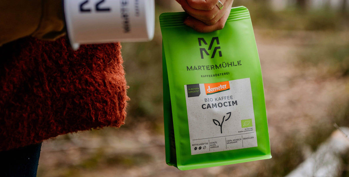 Frau mit Martermühle Bio Kaffee Camocim Packung in der Hand.